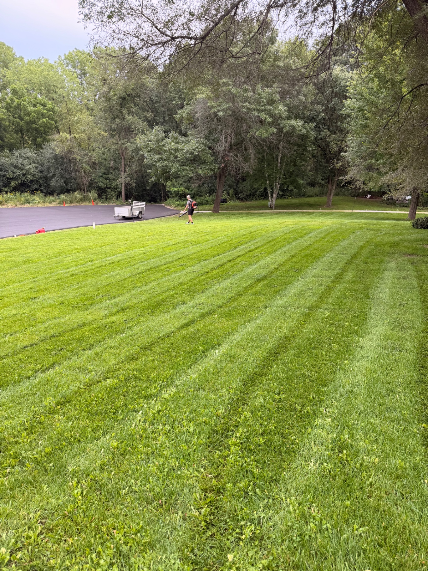 North Star Turf crew member blowing a driveway clean after mowing